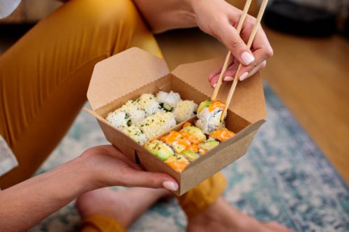 woman enjoying takeaway sushi at home - junk food stock pictures, royalty-free photos & images