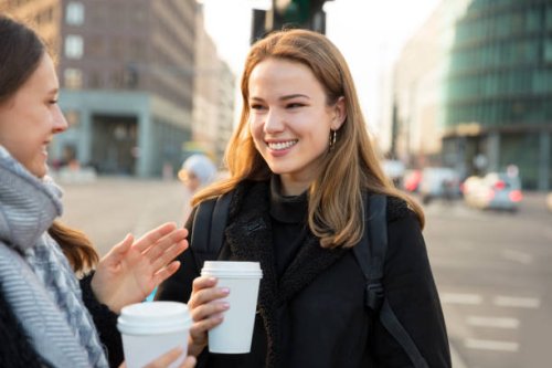 woman friends having coffee and talking on the city street - junk food stock pictures, royalty-free photos & images