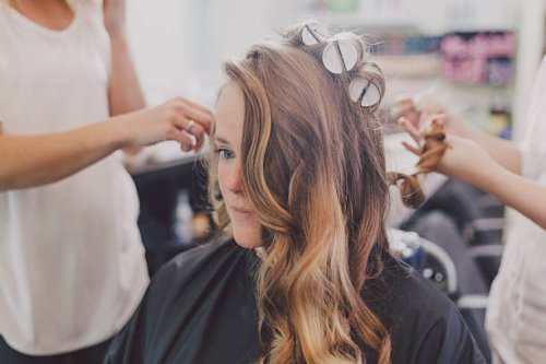 woman getting curls from hairdressers - hairstyle stockfoto's en -beelden