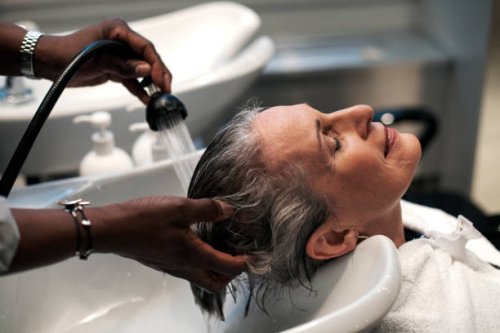 woman getting hair washed at salon - hairstyle fotografías e imágenes de stock