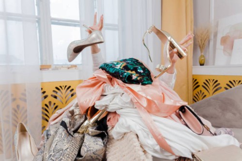 woman hands out of a pile of clothes and accessories on the floor. too much shopping. shopaholic girl. shopping addiction concept. - fashion stock pictures, royalty-free photos & images