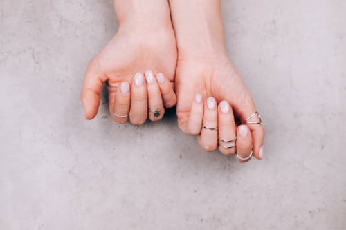 woman hands with nude pink manicure and with many various silver rings on fingers on concrete gray background. concept of trendy boho style. flat lay style with copy space - nails art stock pictures, royalty-free photos & ima