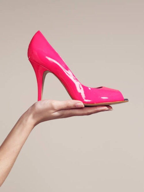 woman holding a high heel shoe - fashion stock pictures, royalty-free photos & images