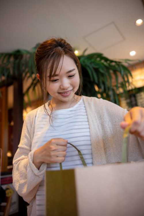 woman holding a paper bag in cafe - junk food stock pictures, royalty-free photos & images