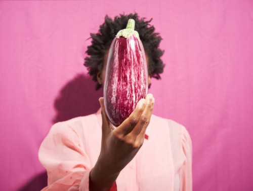 woman holding aubergine in front of face - food stock pictures, royalty-free photos & images