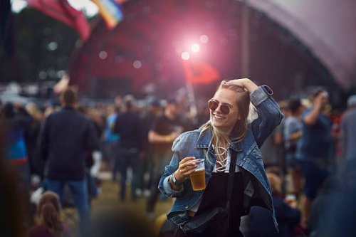 woman holding beer and laughing at concert - concert stock pictures, royalty-free photos & images