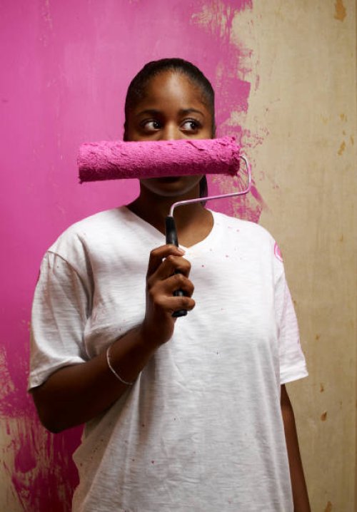 woman holding paint roller across face - home decoration stock pictures, royalty-free photos & images