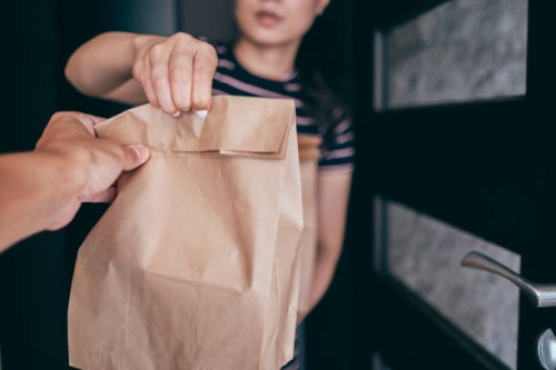 woman holding paper bag with take out food, home delivery, food order - junk food stock pictures, royalty-free photos & images