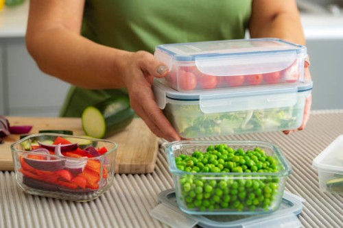 woman holding plastic airtight food containers filled with vegetables ready for be stored in the refrigerator - food stock pictures, royalty-free photos & images