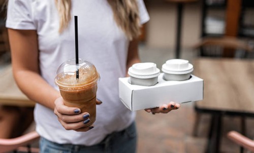 woman holding plastic glass of iced coffee - junk food stock pictures, royalty-free photos & images