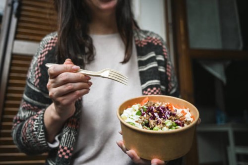 woman holding poke in a cardboard plate. - junk food stock pictures, royalty-free photos & images