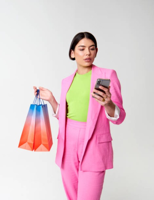 woman holding shopping bag and smartphone - fashion stock pictures, royalty-free photos & images