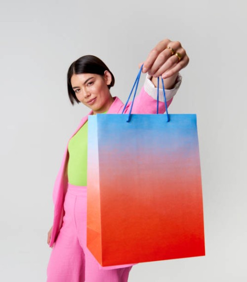 woman holding shopping bag toward camera - fashion stock pictures, royalty-free photos & images