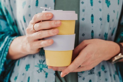 woman holding to go take out coffee cup - junk food stock pictures, royalty-free photos & images