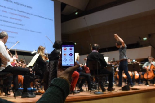 Woman holds a smartphone on January 19, 2018 during a rehearsal at the Orchestre national de Lille in the French northern city of Lille, where the...