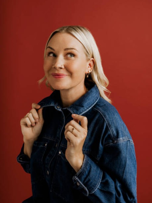 woman in denim jacket and pants on red background in studio - fashion stock pictures, royalty-free photos & images