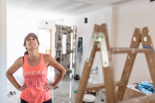 woman in her house doing renovations looks at the drywall ceiling and plans the work - home decoration stock pictures, royalty-free photos & images
