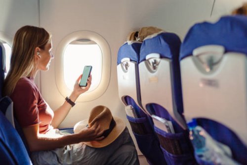 woman in the aircraft holding smart phone with white screen - travel stock pictures, royalty-free photos & images