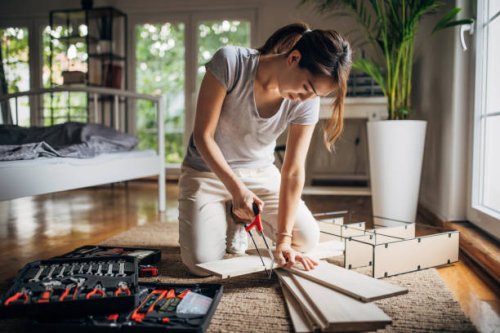 woman is assembling shelf at home - home decoration stock pictures, royalty-free photos & images