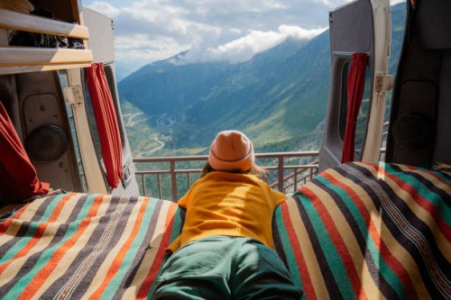woman laying in camper van overlooking furka pass in switzerland - travel stock pictures, royalty-free photos & images