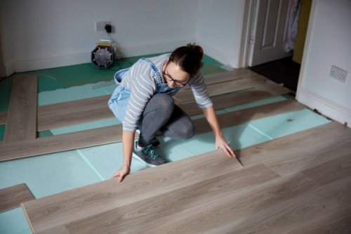 woman laying new floorboards in the living room of a house under renovation. - home decoration stock pictures, royalty-free photos & images