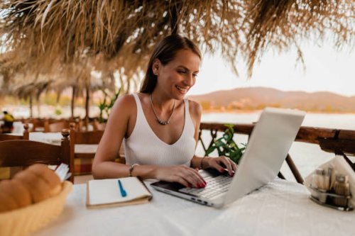 woman learning and using a laptop in a restaurant at the seaside - travel stock pictures, royalty-free photos & images