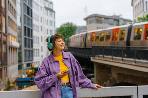 woman listening to music in headphones on the background of subway in hamburg - travel stock pictures, royalty-free photos & images