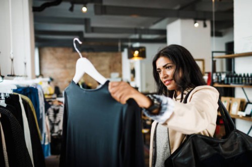 woman looking at blouse while out shopping - fashion stock pictures, royalty-free photos & images
