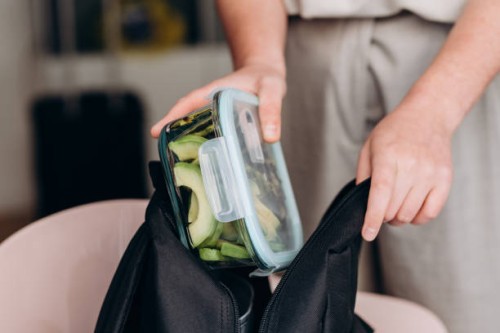 woman makes a healthy lunch at the lunch box zucchini pancakes and avocado salad , healthy lunch to go - junk food stock pictures, royalty-free photos & images