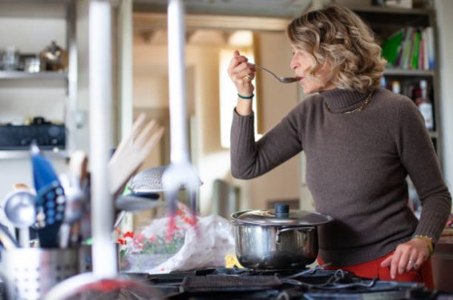 woman making a hearty soup, tasting from spoon - food stock pictures, royalty-free photos & images