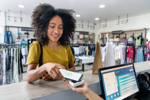 woman making a mobile payment at a clothing store - fashion stock pictures, royalty-free photos & images