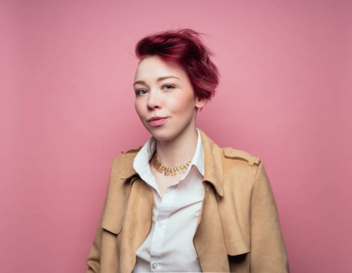 woman on pink background wearing leather jacket - fashion stock pictures, royalty-free photos & images