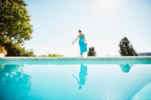 woman on pool deck of vacation home - fashion stock pictures, royalty-free photos & images