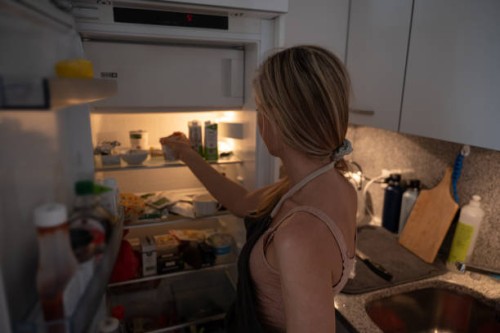 woman opens fridge and looks for ingredients - junk food stock pictures, royalty-free photos & images