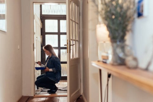 woman painting a wainscoted wall in her house. - home decoration stock pictures, royalty-free photos & images
