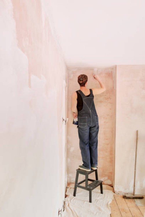 woman painting newly plastered wall - home decoration stock pictures, royalty-free photos & images
