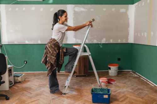 woman painting standing on a ladder - home decoration stock pictures, royalty-free photos & images
