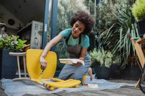 woman paints an old chair in the back yard - home decoration stock pictures, royalty-free photos & images