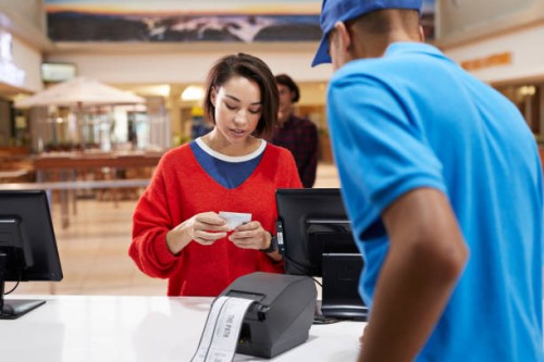 woman paying through credit card at ticket counter - junk food stock pictures, royalty-free photos & images