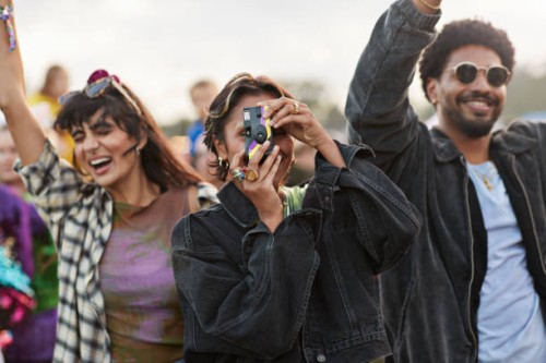 woman photographing against dancing friends - concert stock pictures, royalty-free photos & images