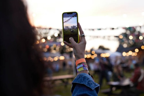 woman photographing bunting through smart phone - concert photos et images de collection