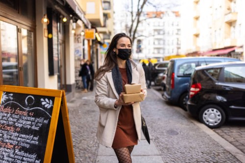woman picking up her ordered food from a restaurant during pandemic - junk food stock pictures, royalty-free photos & images