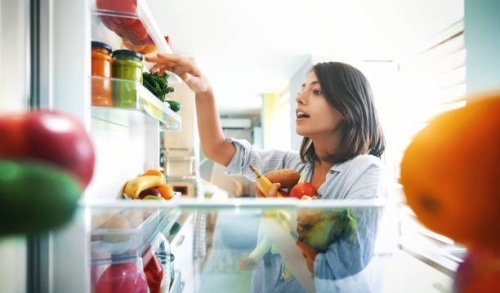 woman picking up some fruits and veggies from the fridge - food stock pictures, royalty-free photos & images