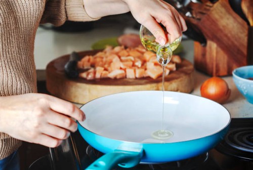 woman pouring olive oil into the skillet. - food stock pictures, royalty-free photos & images