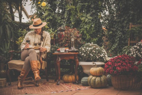 woman reading a book and drinking wine in the garden - garden decoration stock pictures, royalty-free photos & images