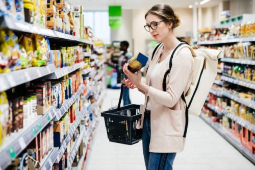 woman reading food item label in supermarket - food stock pictures, royalty-free photos & images