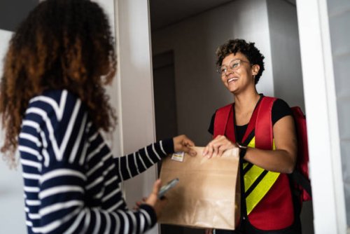 woman receiving delivery at home - junk food stock pictures, royalty-free photos & images