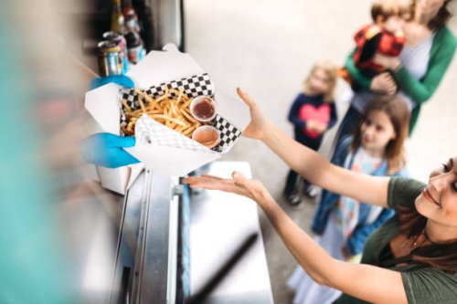 woman receiving order at food truck - junk food stock pictures, royalty-free photos & images