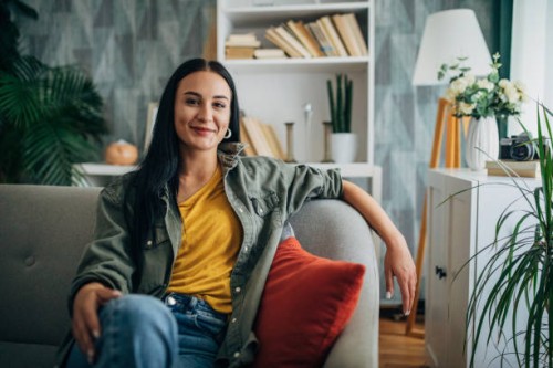 woman relaxing on a couch with a smile, front view. - home decoration stock pictures, royalty-free photos & images