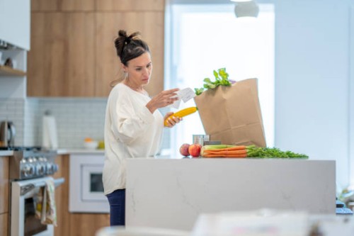 woman reviewing grocery bill - food stock pictures, royalty-free photos & images